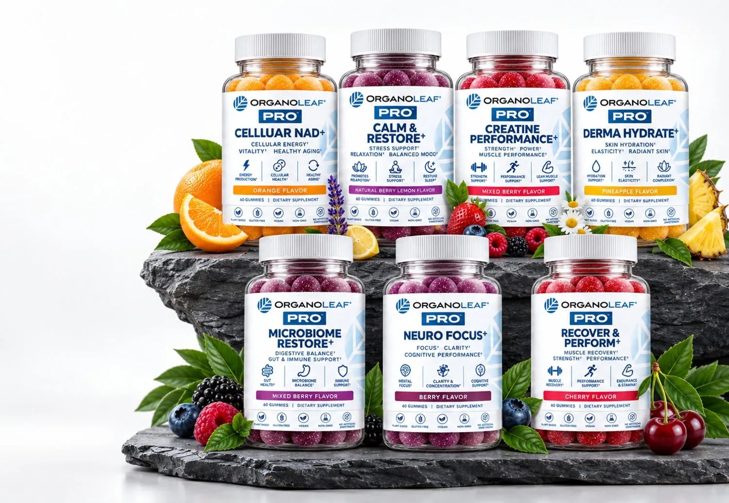 All seven Organoleaf Pro gummy bottles arranged on a slate plinth with fresh fruit — Cellular NAD+, Calm & Restore, Creatine Performance, Derma Hydrate, Microbiome Restore, Neuro Focus and Recover & Perform.